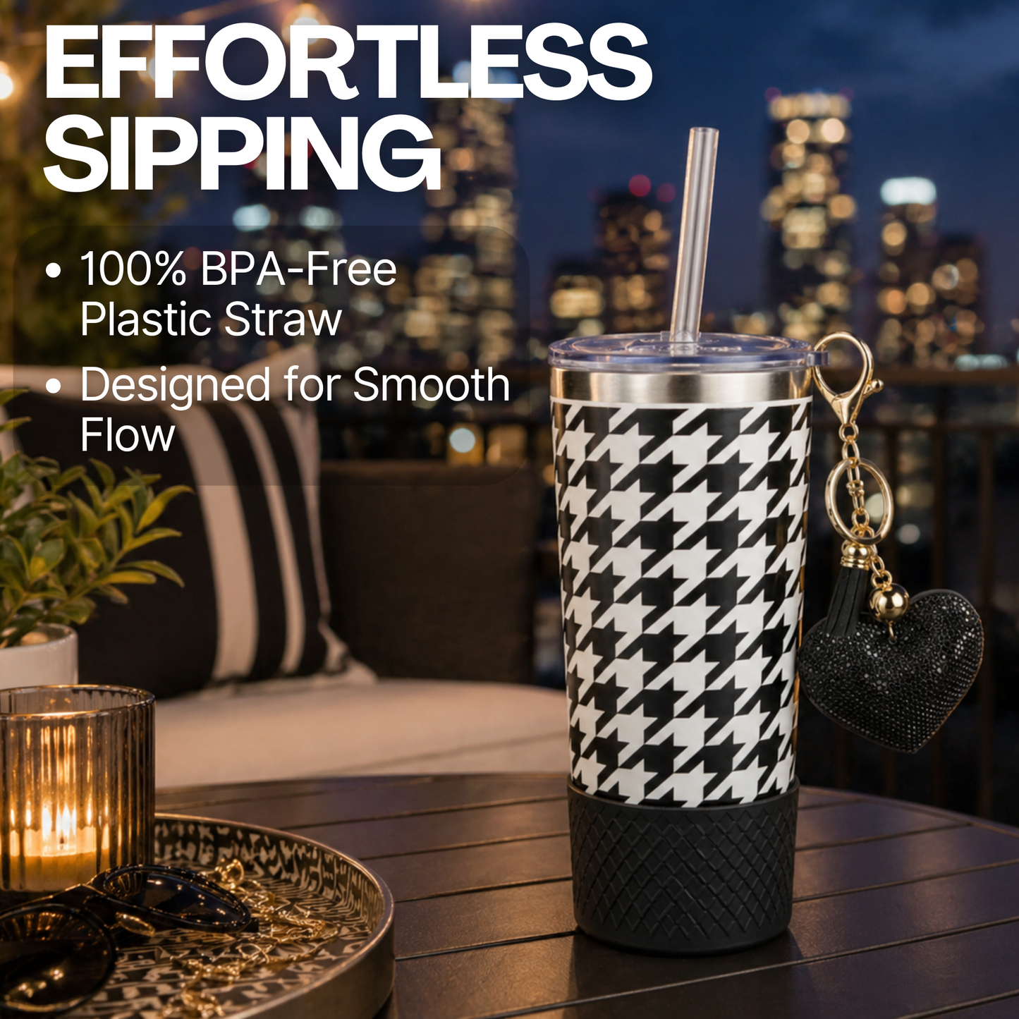 Biddlebee 20oz signature black and white charm tumbler with straw on a table with cityscape background