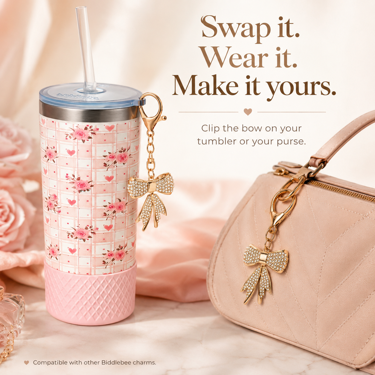 Pink floral tumbler with gold bow charm and matching pink handbag on a soft pink background.