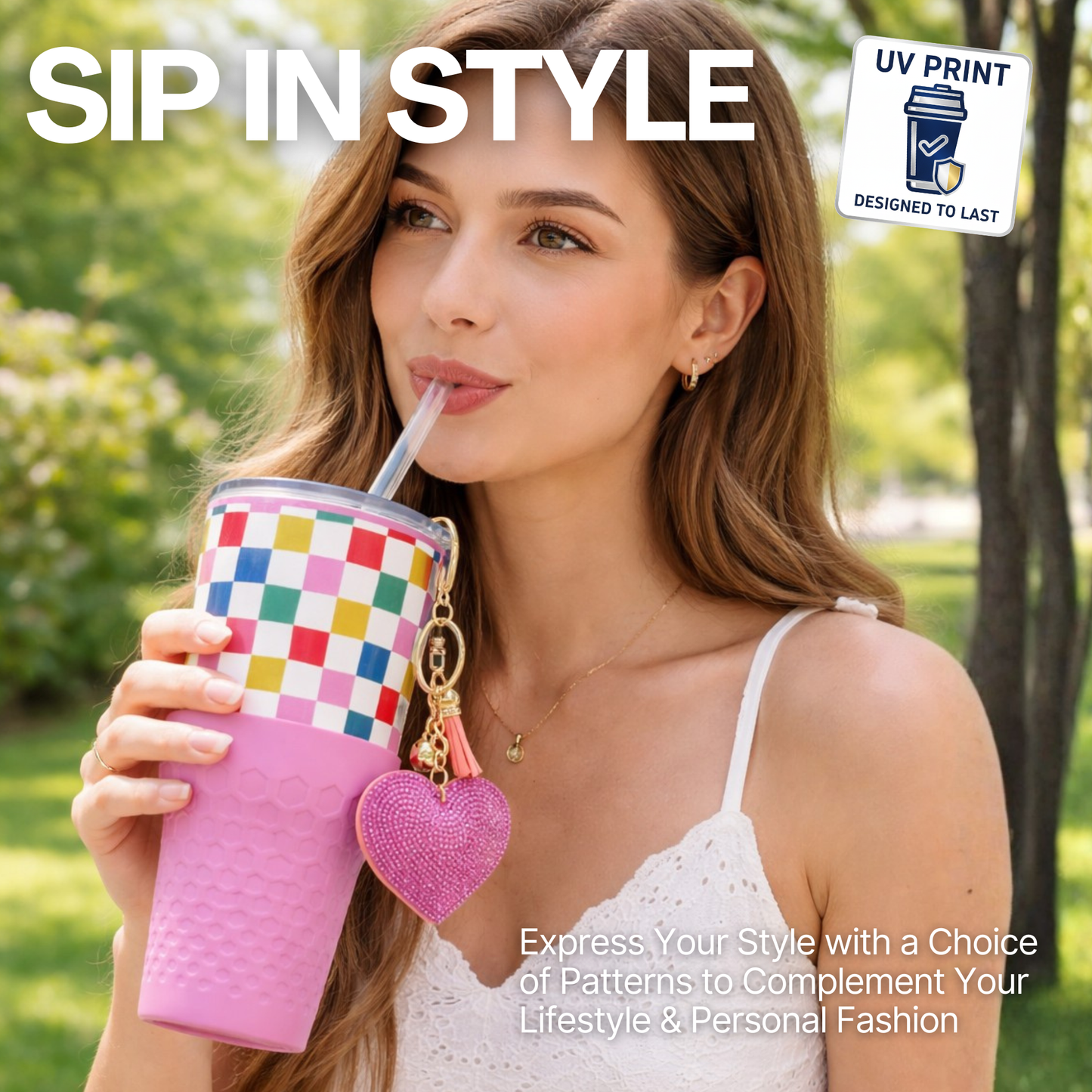 Woman holding a Biddlebee 30oz Happy Check Charm tumbler with easy sip straw, shimmer heart charm and silicone boot, standing outdoors.