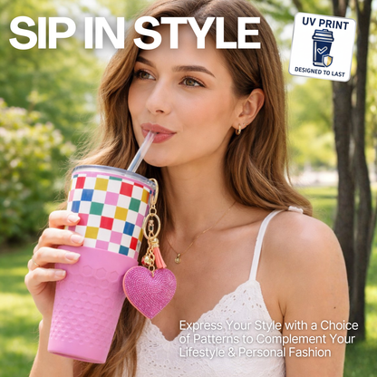 Woman holding a Biddlebee 30oz Happy Check Charm tumbler with easy sip straw, shimmer heart charm and silicone boot, standing outdoors.