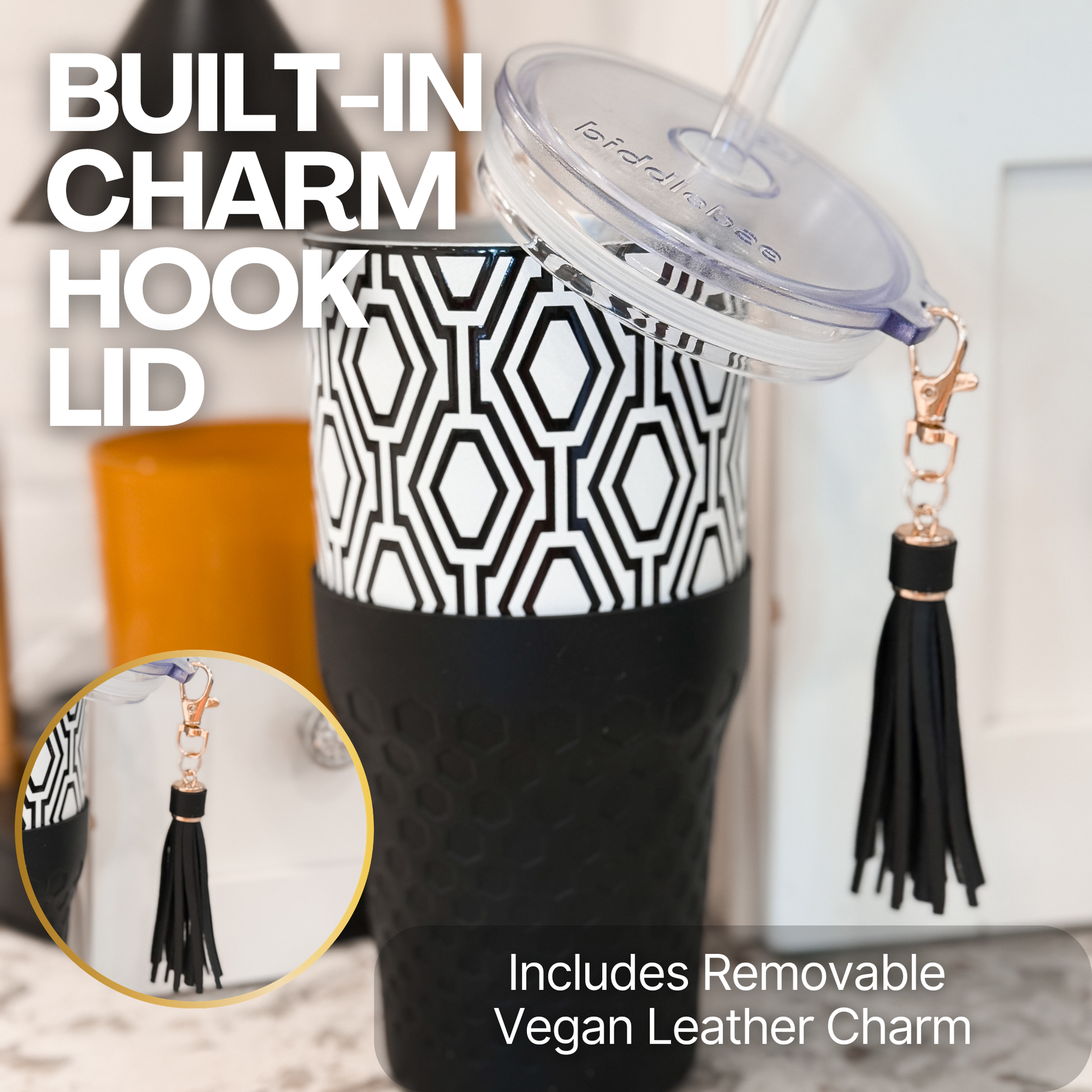 Biddlebee 30oz Black & White Charm tumbler with a straw lid, vegan tassel and silicone boot on a kitchen countertop
