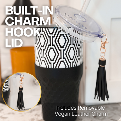 Biddlebee 30oz Black & White Charm tumbler with a straw lid, vegan tassel and silicone boot on a kitchen countertop