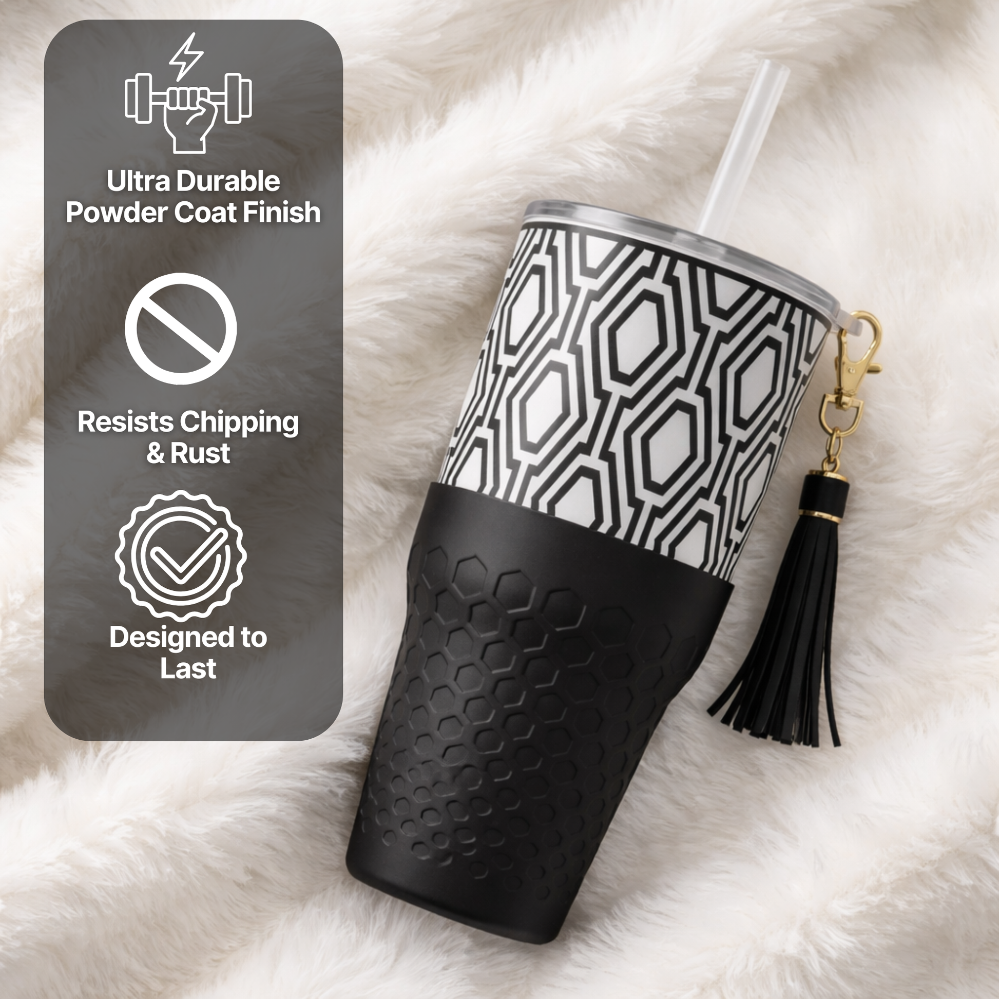 Biddlebee 30oz Black & White Charm tumbler with a straw lid, vegan tassel and silicone boot on a white background on a white fluffy surface, with durability features displayed.