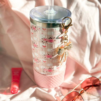 Tumbler with floral design and keychain on a soft pink background