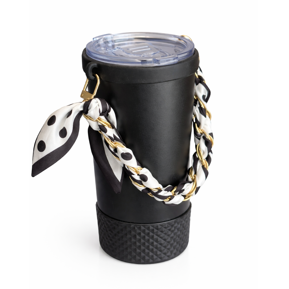 Biddlebee Brew Black coffee tumbler  with a polka dot scarf and gold chain on a white background