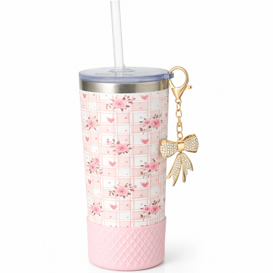 Pink floral-patterned tumbler with a gold bow keychain on a white background
